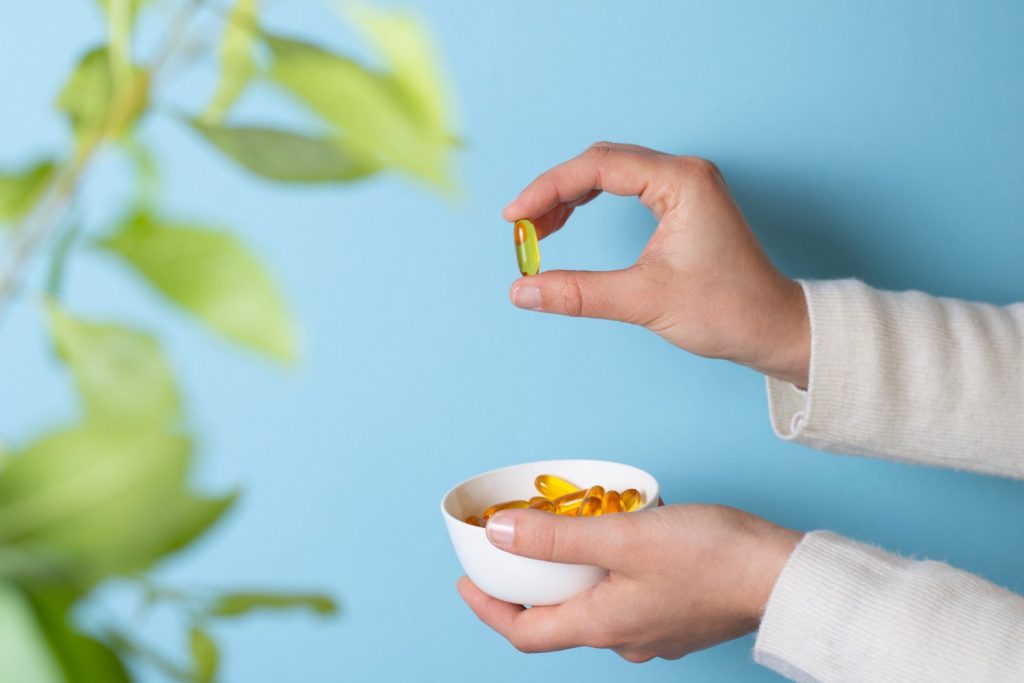 Pessoa a tomar cápsula de vitamina para queda de cabelo